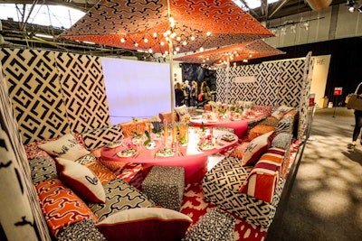The Kravet table was created by Diane von Furstenberg and celebrated the fashion designer’s first collection for the fabric brand. Mixing prints, colors, unexpected patterns, and scale, the tableau held a low table surrounded by wide cushion seating and umbrellas. Pops of red, orange, and blue accented the black-and-white color scheme.