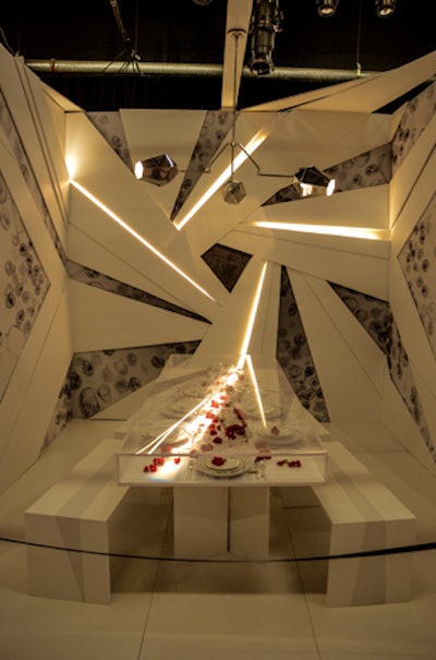 The New York School of Interior Design table, which was designed by Kati Curtis, played with light and shadow. Streaks of lightning-bolt-like light cut across the Lucite dining table, highlighting the settings and simple floral buds that were ensconced within the tabletop.