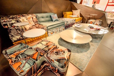 The environment for Roche Bobois Paris, designed by Hariri & Hariri Dining, was an example of exotic, primal, and fashion-forward ideas thanks to an angular architectural form enclosing the iconic Mah Jong sofas dressed by Jean Paul Gaultier.