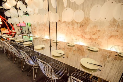 Circular discs anchored to a stainless steel table set the scene at the imposing Studios architecture table, which had a waterfall-like, nature-inspired wall backlit with recessed floor lighting.