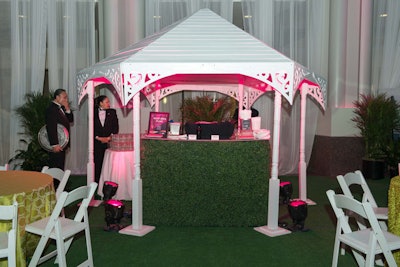 Grass-covered high-top tables, white lounge chairs, and a gazebo bar created an indoor garden to one side of the atrium.