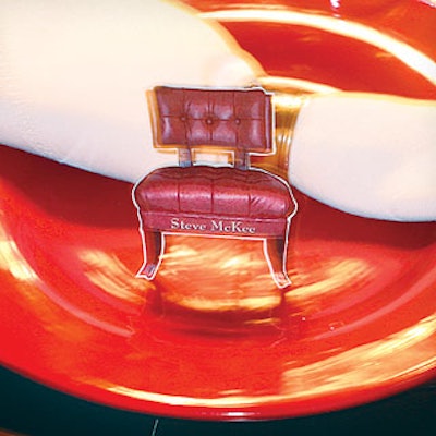 Interior designer David Easton created name cards shaped like miniature chairs for furniture manufacturer Henredon's red-themed table.
