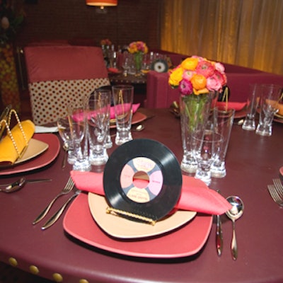 Rick Shaver and Lee Melahn from Shaver/Melahn Studios created fun place settings for the New York Design Center's table—actually three banquettes—that incorporated 45 RPM records customized with guests' names to carry out the design's overall vibe of a 1950's supper club.