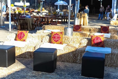 Colorful throw pillows topped hay bale seating.