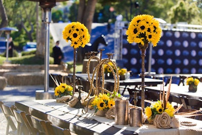 Picnic-style tables and rustic chairs provided down-home seating for guests at the Roth Capital Partners event. The decor was inspired by the event's country music headliner, Florida Georgia Line.