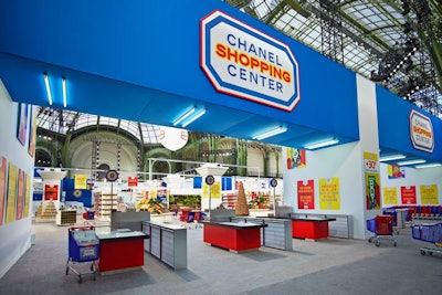 For his Fall/Winter 2014 Chanel show on March 4, Karl Lagerfeld reimagined the Grand Palais in Paris as a full-scale supermarket-cum-shopping center. The venue held imitation checkout aisles—complete with register counters—specially branded grocery carts, and lane markers. Vertical bars of red, blue, and yellow added graphic detail to the walls.