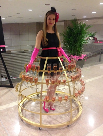 A model wearing a skirt of pink champagne flutes welcomed guests to the Pink Tie Party on Thursday.