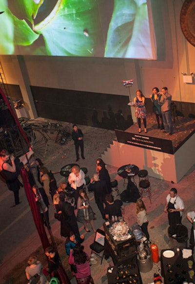 Guests who bid on the pastry drone stood on a grassy stage on the ground floor, and the drone hovered nearby as they plucked sweets off its tray.