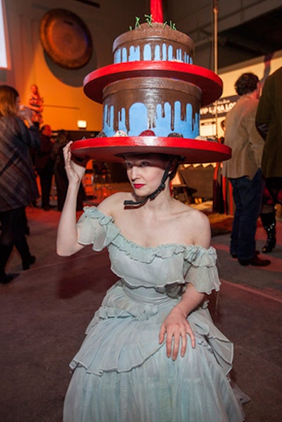 A performer with a giant cake atop her head showcased a new service device from the 'Redmoon for Hire' program, which lets planners book Redmoon performers to entertain at events.