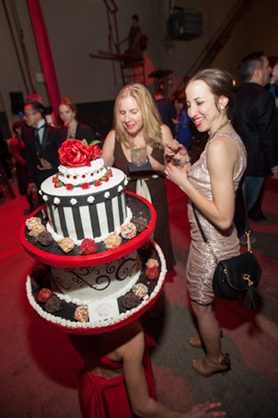 A pastry-decked performer bowed down to let guests choose treats off her Doughnut Vault headpiece.