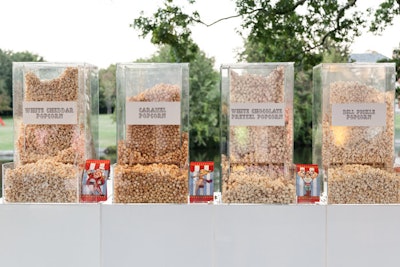 At a flavored popcorn station, custom-built stands had a false fill at the top so they never appeared empty. Serving staff refilled the popcorn at the base as needed.