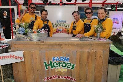 Arrangements from floral stylist Sophie Wolanski topped wood plank bars created by SFDS Fabrication & Design. Servers wore farm-appropriate denim overalls and long-sleeved T-shirts with the game logo.