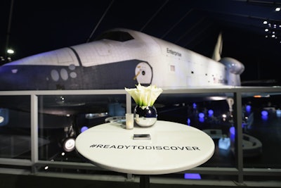 Following the debut, guests proceeded into the Shuttle Pavilion for drinks and hors d'oeuvres. The Enterprise served as a backdrop to the evening. Semicircular lounge areas spread around the shuttle, and cocktail tables were marked with the night's official hashtag.