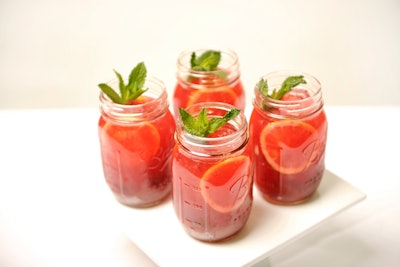 Frozen berry and bourbon lemonades with strawberries, blueberries, blackberries, and raspberries, topped with mint and served in Mason jars, by Tasty Catering in Chicago