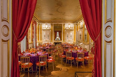 The gilded room had a bolder look this year with deep purple table linens accented by bright orange napkins, place settings, and seat cushions.