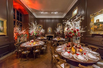 By keeping the dark wood tables linen-free, the white place settings and tall floral arrangements stood out in a chocolate-colored gallery.