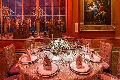 Pin spots on the center of each table drew attention to the floral arrangements as guests meandered through the gallery rooms before dinner. The napkin origami featured a taller standing fold.