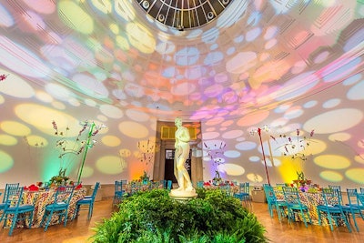 The rotunda continued the garden atmosphere with a centralized marble statue surrounded by abundant plants and colorful tables reminiscent of flowers in a garden.