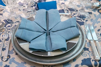 Perfect Settings topped each place setting with a different design of napkin origami, matching the color palette of that room.