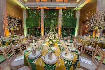 Green trees, gobos, and more draping created the look of a live garden wall at either end of the atrium.