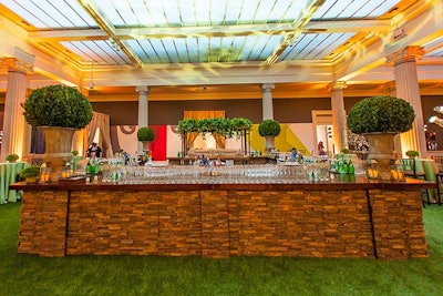 On a bridge over the atrium, Perfect Settings erected a stone-style, four-sided bar with topiaries on each corner and additional faux-grass flooring.