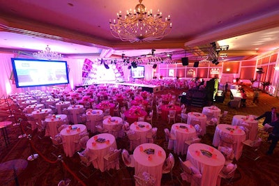 Atmosphere Inc. washed the ballroom in pink lighting to complement the white table linens and runway.