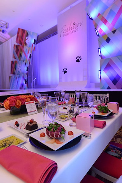 The white 'V.V.I.P.' tables lining the runway, for sponsors at the $10,000 level, had simple pink napkins, black chargers, and a single bright table runner with the majority of color in the floral arrangements. The gift bags included dog treats, food, and paraphernalia from Wagtime, a pet spa and boutique.