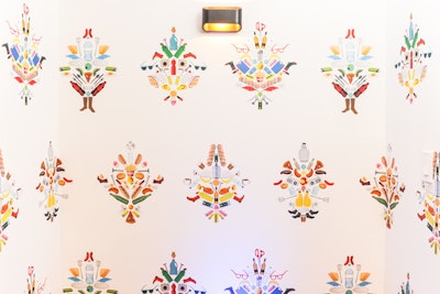 The walls at the entrance to the event were covered with customized wallpaper that turned colorful illustrations of common household items into geometric patterns.
