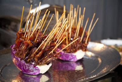 Jewell Events Catering provided a spread of savory snacks, including ancho-chili-rubbed bacon lollipops on long bamboo skewers, stemming from a purple cabbage base.