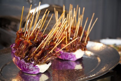 Jewell Events Catering provided a spread of savory snacks, including ancho-chili-rubbed bacon lollipops on long bamboo skewers, stemming from a purple cabbage base.