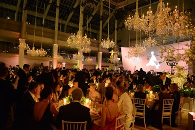 Crystal chandeliers hung at varying heights, with hand-stenciled sisal carpet below. Urns and plinths with blossoming branches were scattered throughout the room, and the bases of sculptures and planters were covered in white wood mimicking the columns in Cecil Beaton's iconic 1948 photo of eight models.