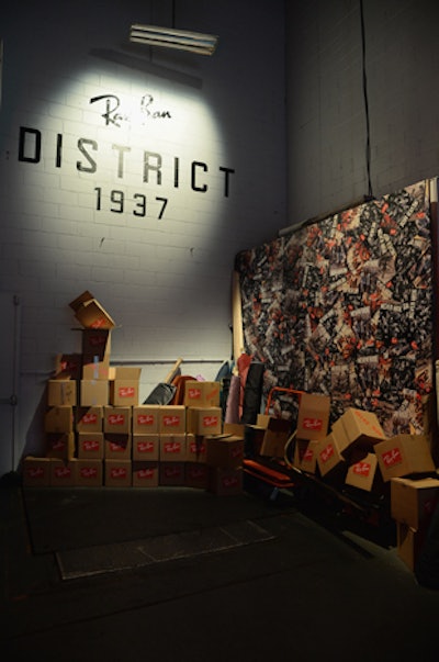 As guests arrived at Stage37 in Hell's Kitchen, they encountered a step-and-repeat comprising dozens of Ray-Ban boxes. Once inside, the entrance through the loading dock served as an initial welcome space filled with factory items such as neon lights, metal scraps, bolts of fabrics, and more box displays.