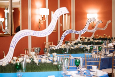 In the Graham Room, where guests had dinner before the show, tables were named after songs from The Sound of Music. They were also decked with blue linens and edelweiss flowers in patches of faux grass. HMR Designs handled the decor.