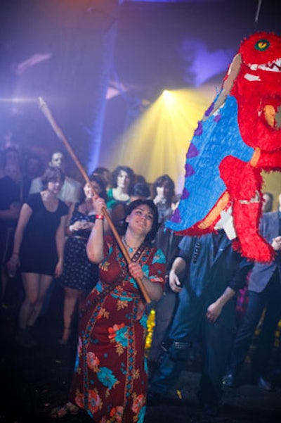 As part of the entertainment at the 2012 Redmoon Theater Spectacle Lunatique in Chicago, guests battered a colorful dinosaur piñata filled with confetti and hand clappers.