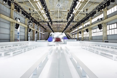 Inside the massive Duggal Greenhouse—the same venue where Alexander Wang showed his fall collection in February—Bureau Betak created a gleaming white venue. To provide guests with an optimal view of the cityscape and river and to put them at window level, Betak constructed an entire floor. The floor was 16.4 feet high and sat on top of the existing ground floor; it was accessed via multiple staircases.