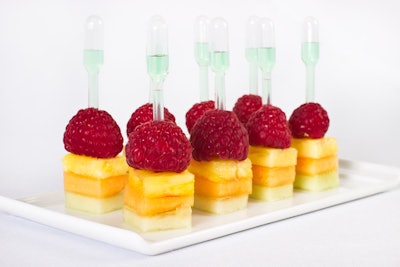Bites of fruit, served with green apple Kool-Aid-filled pipettes, by Puff ’n Stuff in Orlando