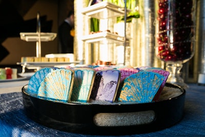 Susan Gage Caterers created the dessert buffet, which included cookies shaped like fans. They were displayed on a tray filled with white rice.