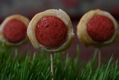 Kobe beef franks wrapped in a cheddar puff pastry, served on lollipop sticks, and paired with honey-mustard sauce and ketchup, by Elegant Affairs in New York