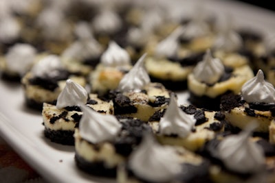 Organic pumpkin cheesecake cut into bite-size rounds, topped with crumbled Oreos and a dollop of whipped cream, by DNA Events Inc. in Austin, Texas