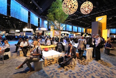 Blue and gold lighting illuminated fiber curtains around the perimeter of Sapphire Now's new networking area to create a subtle division from the rest of the event floor.