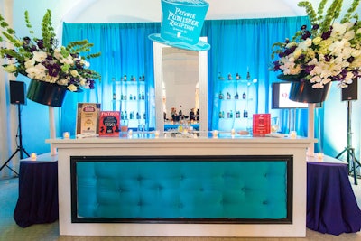 The publisher's reception remained on the second floor within two gallery spaces. Chicka used a vibrant color palette to create the Mad Hatter's Tea Party atmosphere with blue and white draped walls and table linens, and signage printed on a top hat.