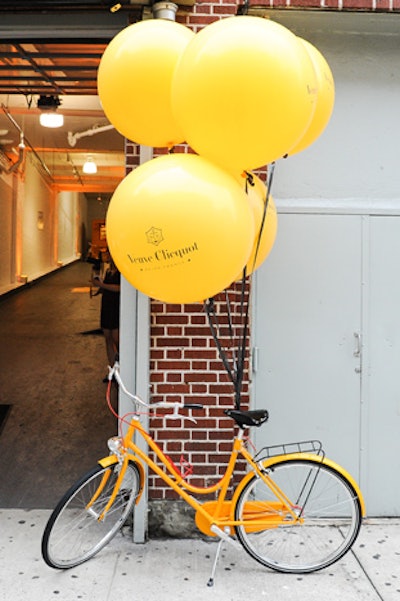 Guests arriving at Industria Superstudio were met by groupings of oversize branded balloons in Veuve Clicquot yellow, along with branded bicycles to echo the event's transportation theme.