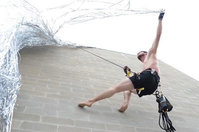 A unique combination of two artists' work was displayed directly overhead as guests emerged into the main gala space. Alex Berlage's 'Second Face' was coupled with Krystian Lyson's 'King’s Madness' for a performance inspired by the tale of Rapunzel, whereby a performer repeatedly attempted to climb up a wall of silver Mylar.