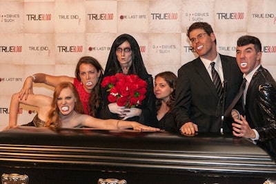 Guests, including True Blood's Deborah Ann Woll (pictured, far left), posed with fake fangs and alongside a coffin at a photo station.