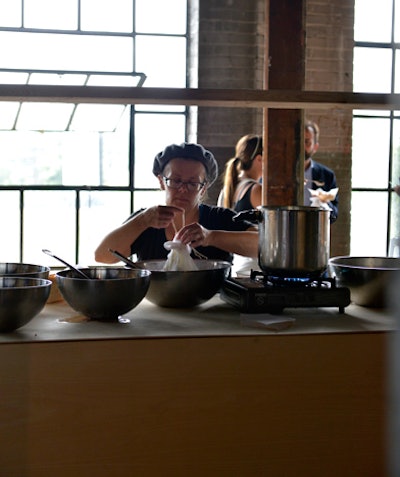 Servers prepared warm ricotta at one of the food stations. The ricotta hung from the ceiling on architectural fabric.