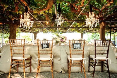 Hanging Classic and Beaded Chandeliers under garden trellis at outdoor wedding reception at Beaulieu Garden