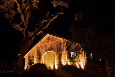 Uplighting of exterior barn and trees create a magical glow after the sun goes down