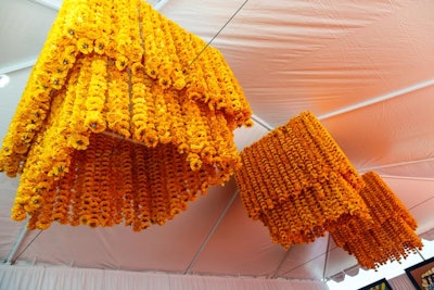 Three chandeliers made from fake orange flowers hung from the tent.