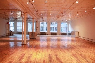 Open loft floor plan with hard wood floors, white walls and tin ceiling