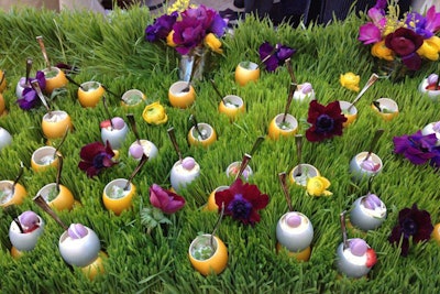 A display from Wolfgang Puck Catering put vanilla-and-wild-strawberry cake topped with tiny lavender macarons into gilded eggshells and set on a bed of grass.